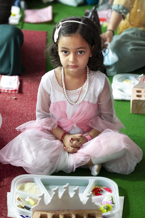 A child participates in the mahapuja rituals