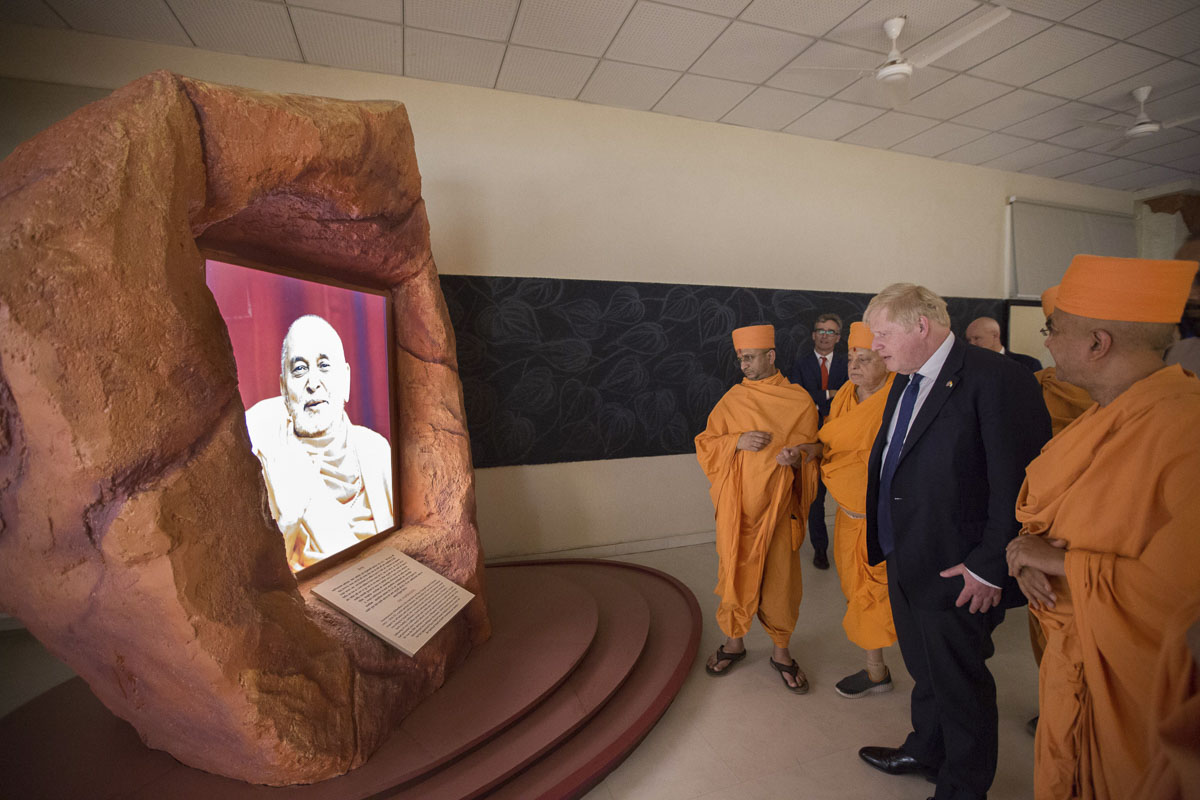 PM Boris Johnson admires an image of Pramukh Swami Maharaj