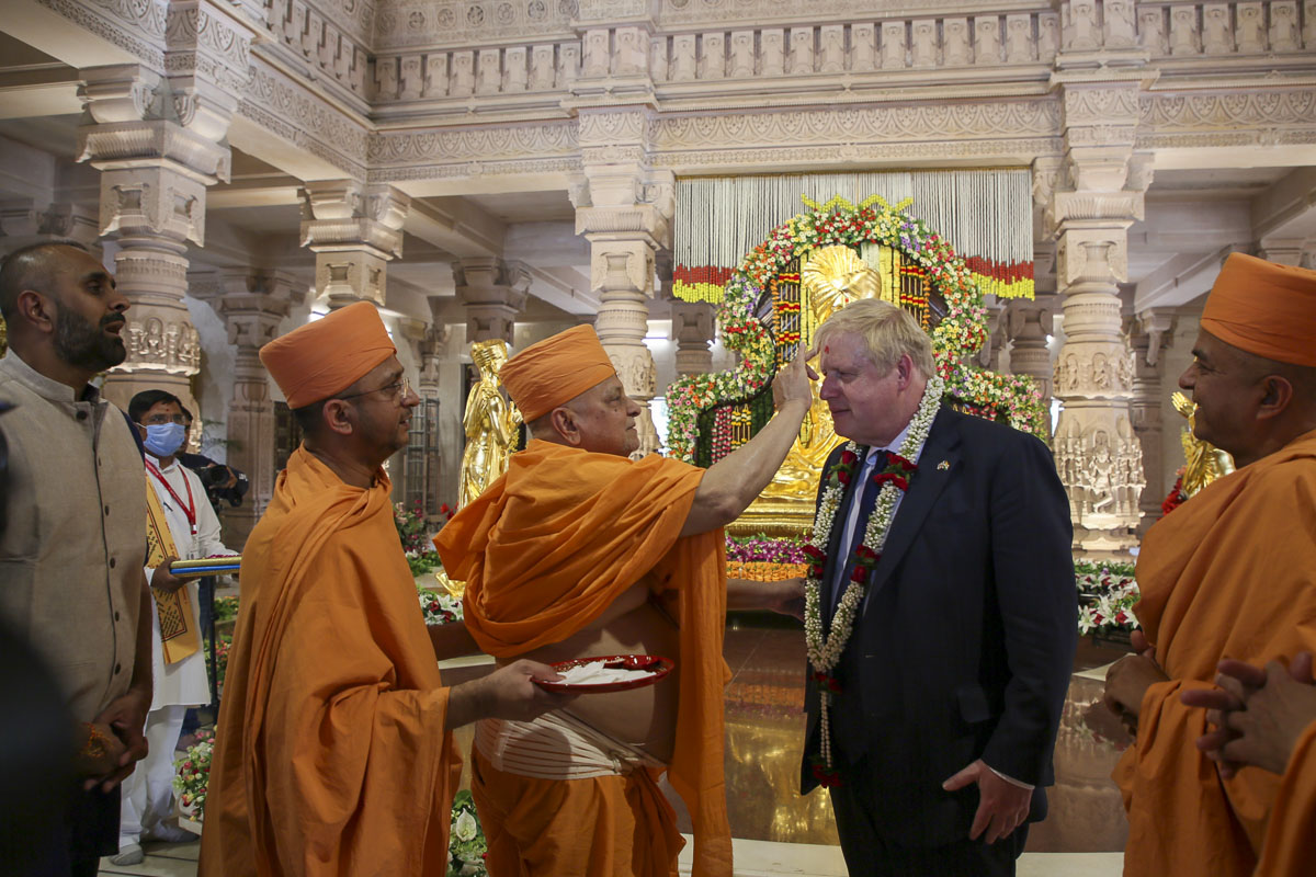 Pujya Ishwarcharan Swami applies a chandlo to PM Boris Johnson