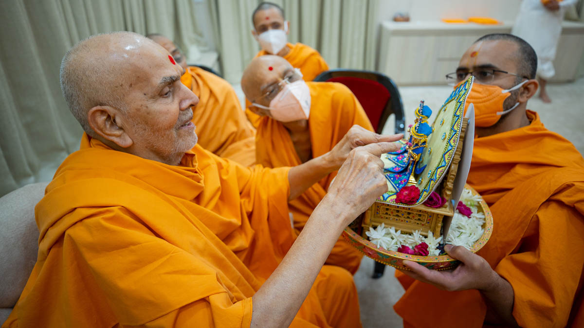 Swamishri engrossed in darshan of Shri Harikrishna Maharaj and Shri Gunatitanand Swami