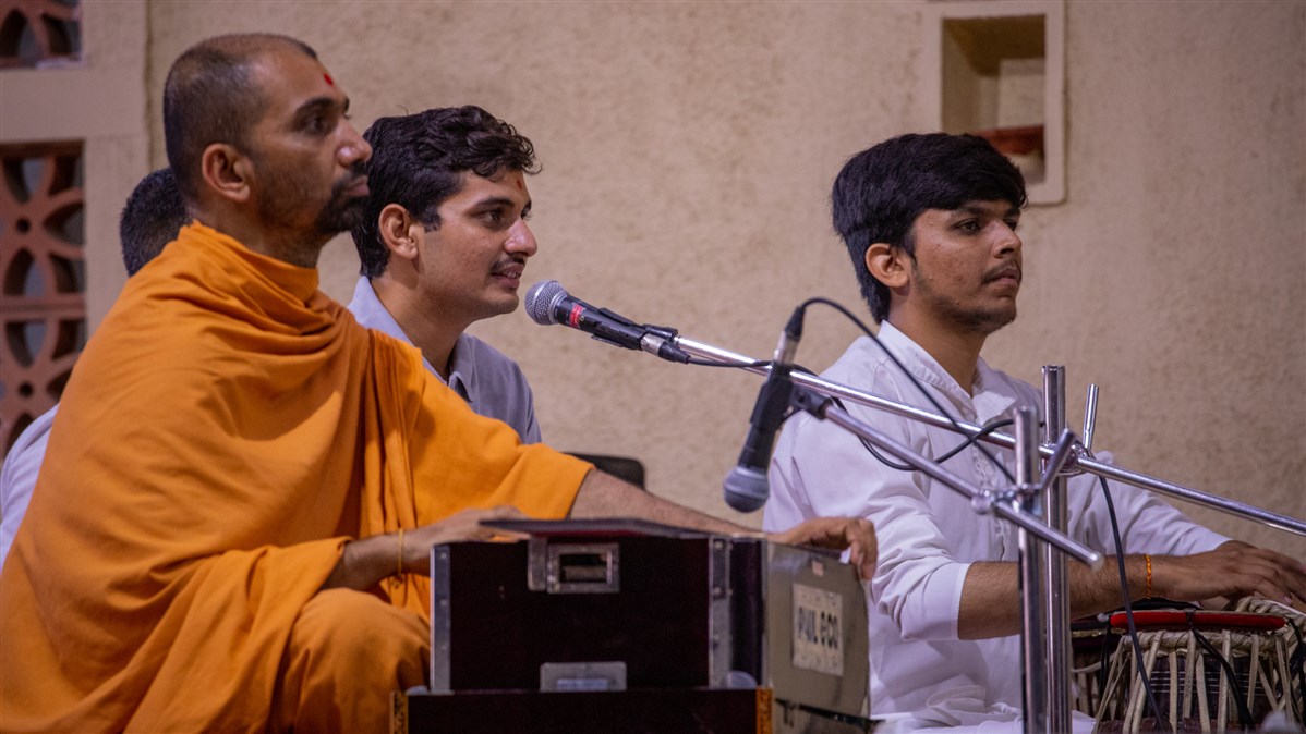 A youth sings a kirtan in Swamishri's morning puja