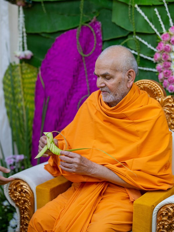Swamishri observes a decorative item