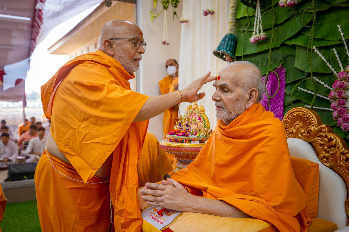 Pujya Ghanshyamcharan Swami applies chandan archa to Swamishri
