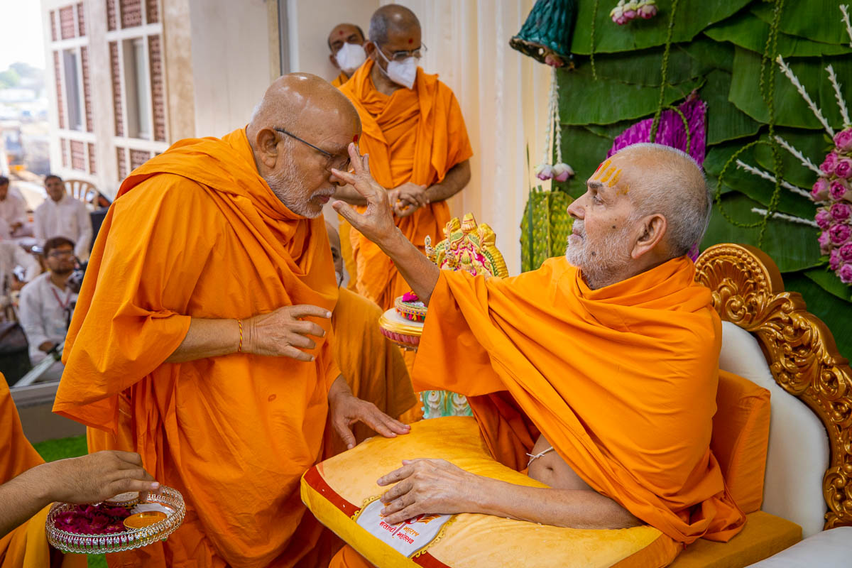 Swamishri applies chandan archa to Pujya Ghanshyamcharan Swami