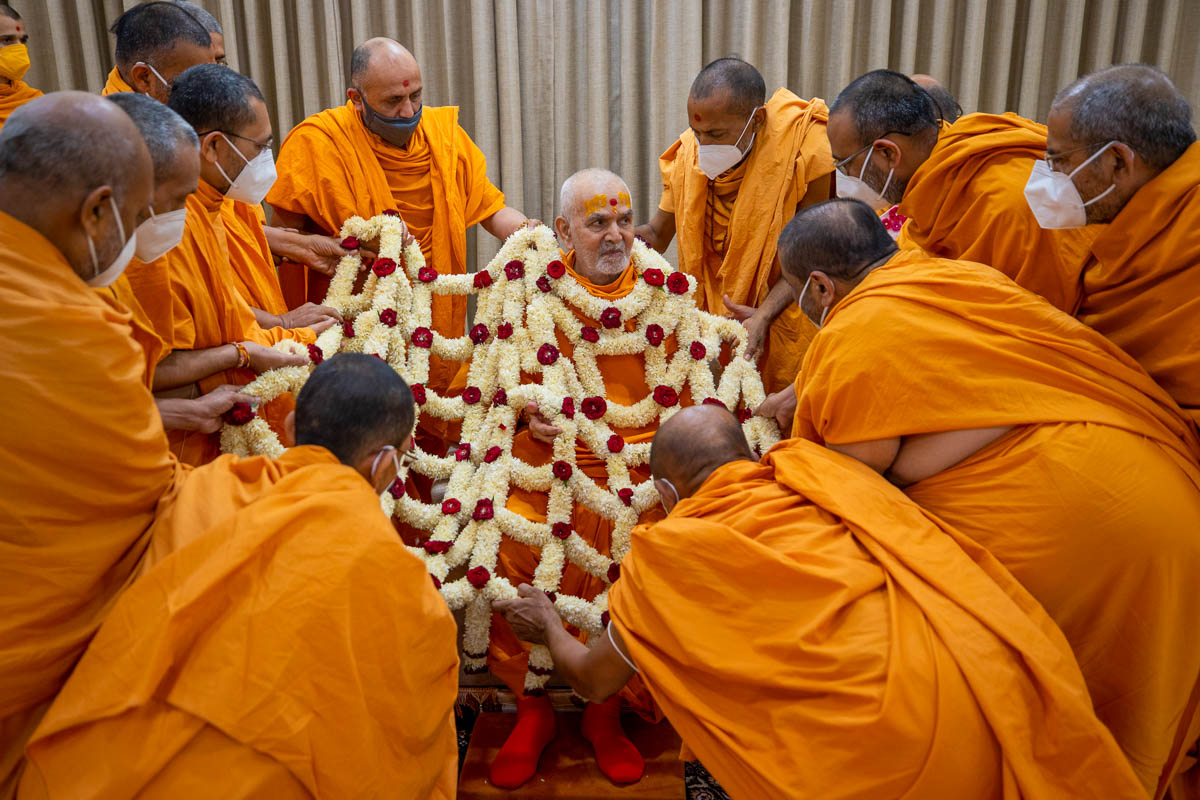 Sadhus honor Swamishri with a shawl of flowers
