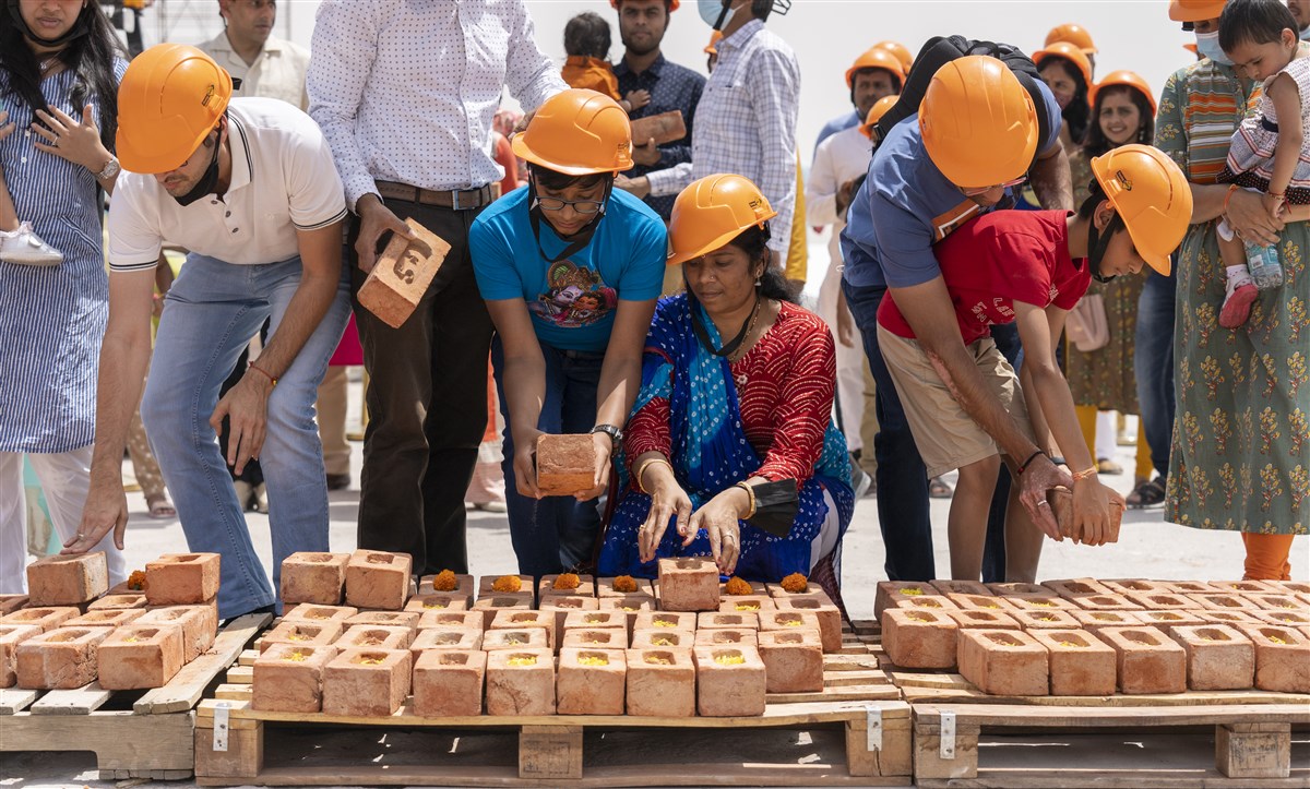 Attendees offering sanctified bricks at the construction site of the BAPS Hindu Mandir