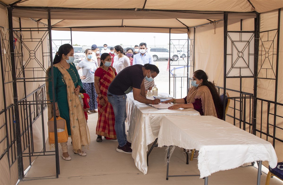 Attendees registering their details for weekly assembly
