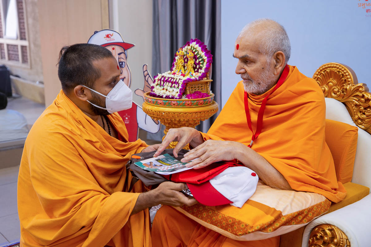 Swamishri sanctifies a kit to be used by the children during the Virat Vyasan Mukti Abhiyan