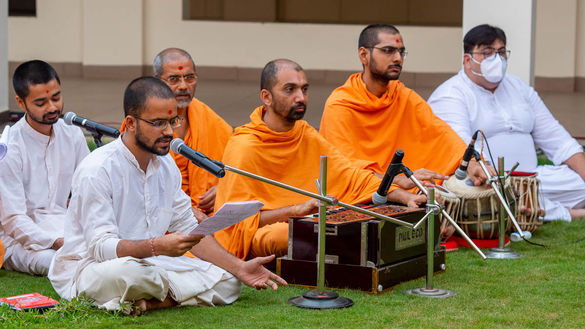Sadhaks sing kirtans in Swamishri's daily puja