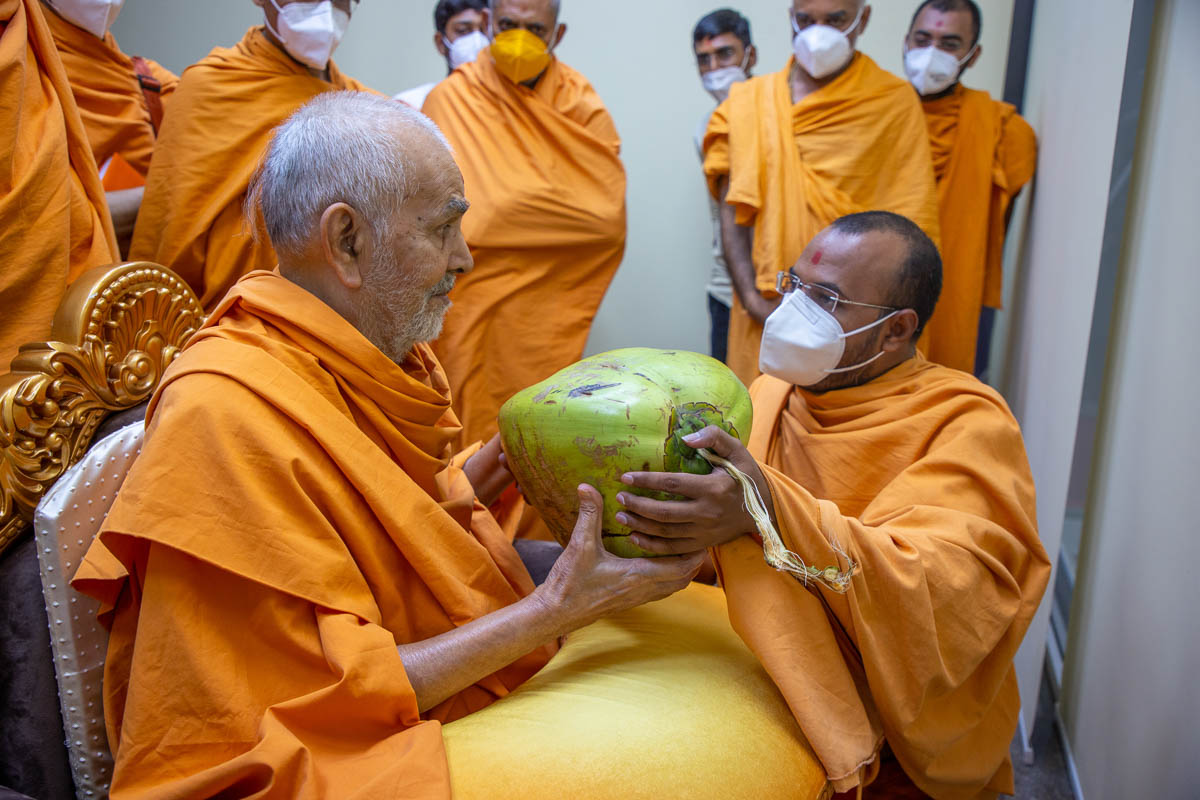 Swamishri sanctifies a coconut