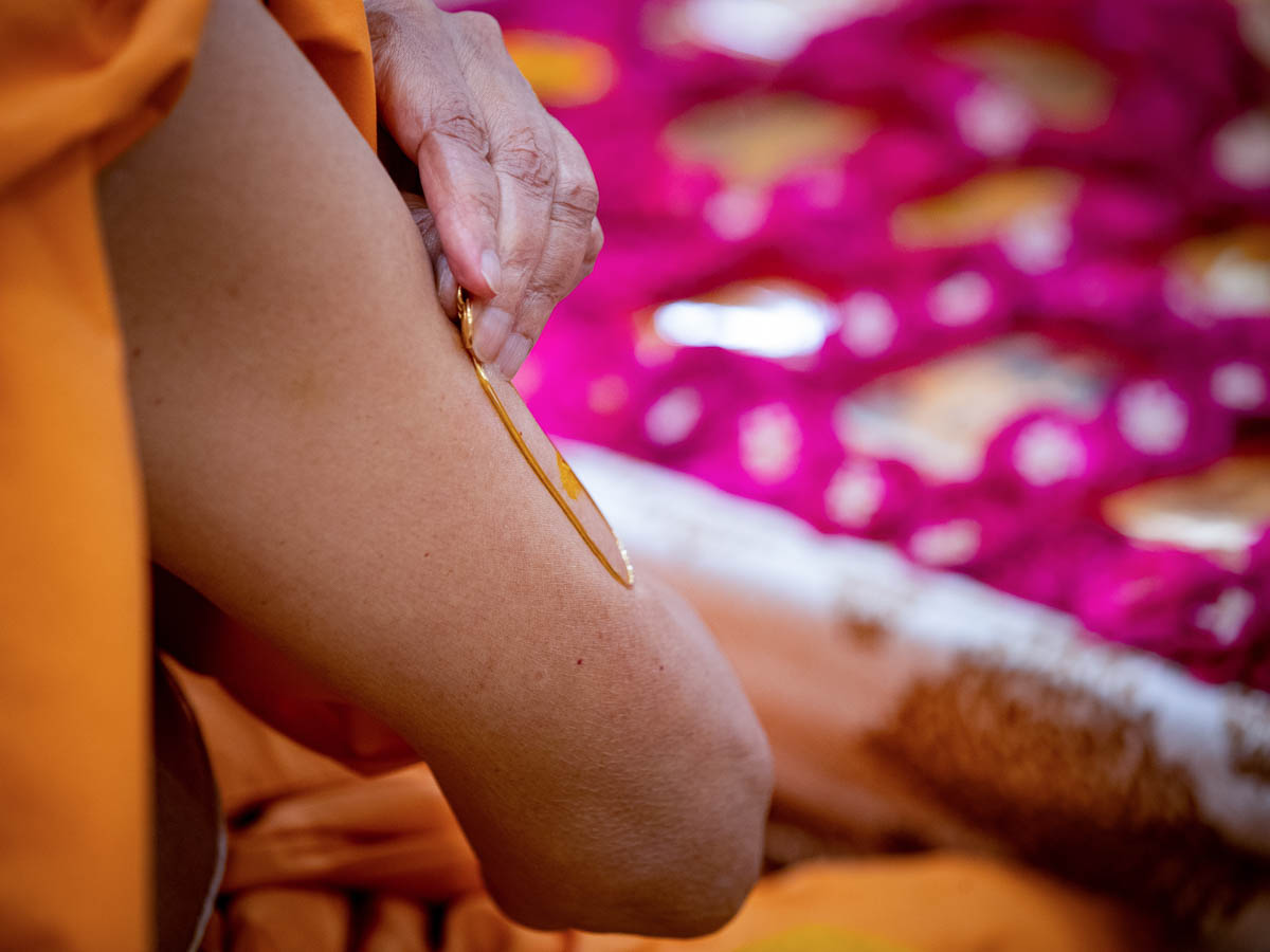  Swamishri applies a tilak on his upper arm