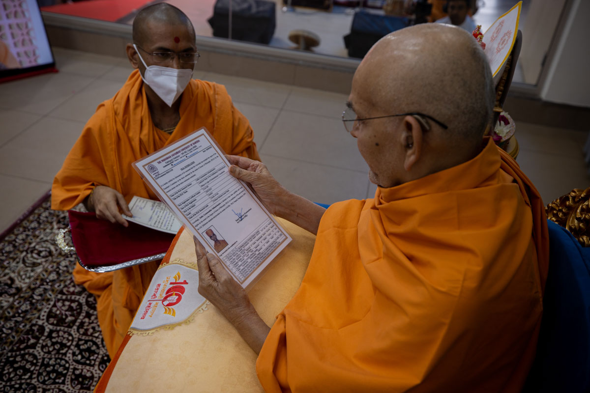 Swamishri sanctifies the PhD certificate awarded to Gnananand Swami