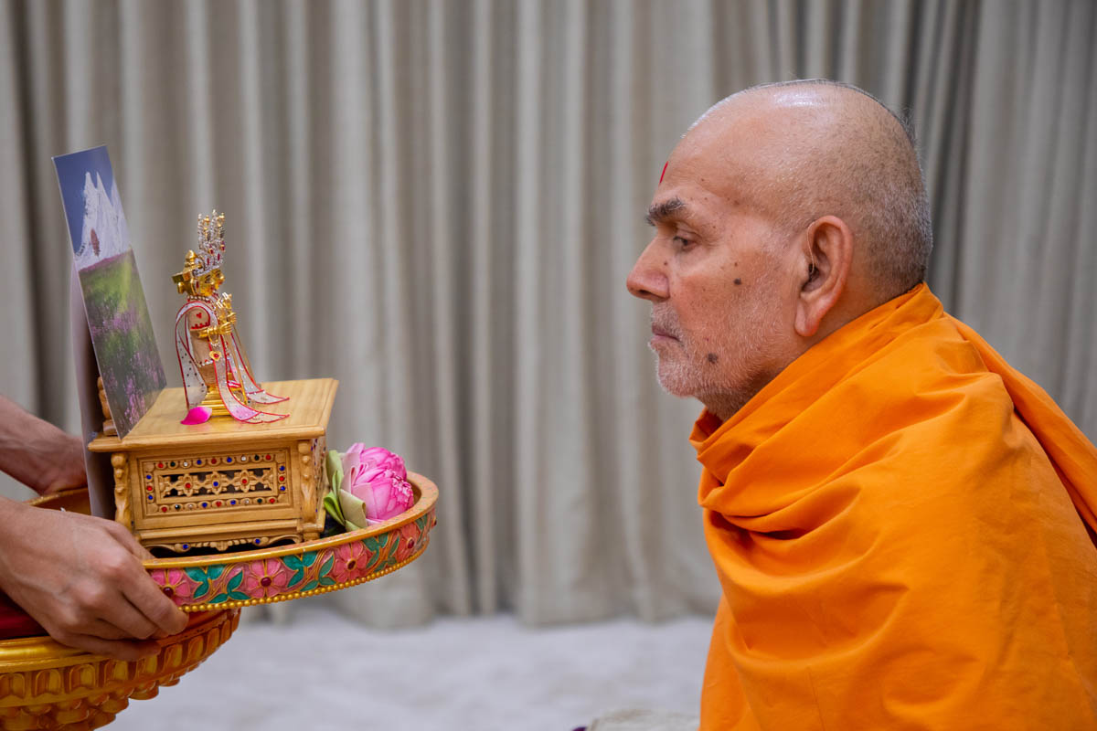 Swamishri observes chandan garments offered to Shri Harikrishna Maharaj and Shri Gunatitanand Swami