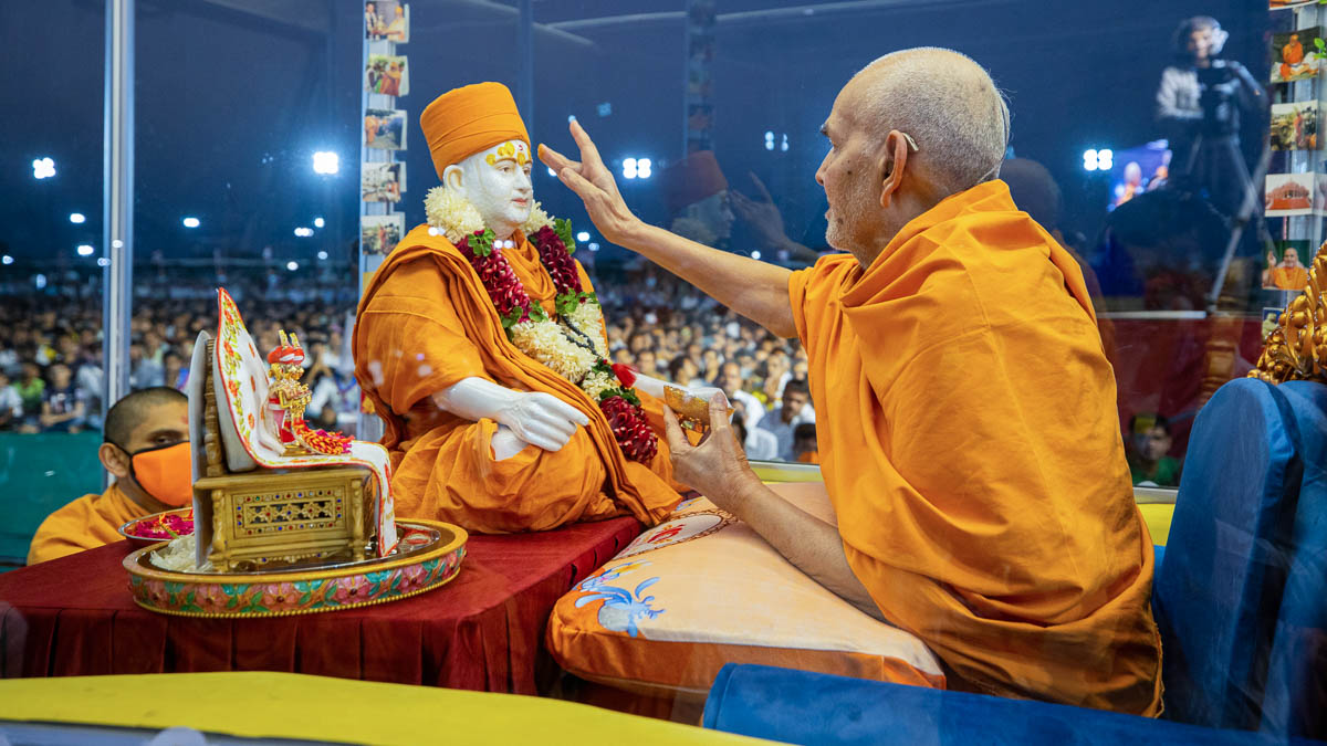 Swamishri applies chandan archa to Brahmaswarup Pramukh Swami Maharaj