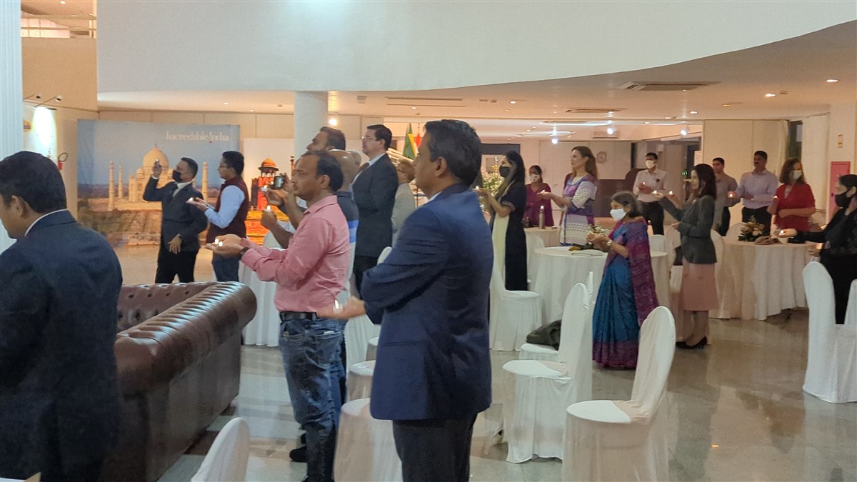 Devotees and well-wishers gathered at the Indian Embassy in Brasilia take part in the arti