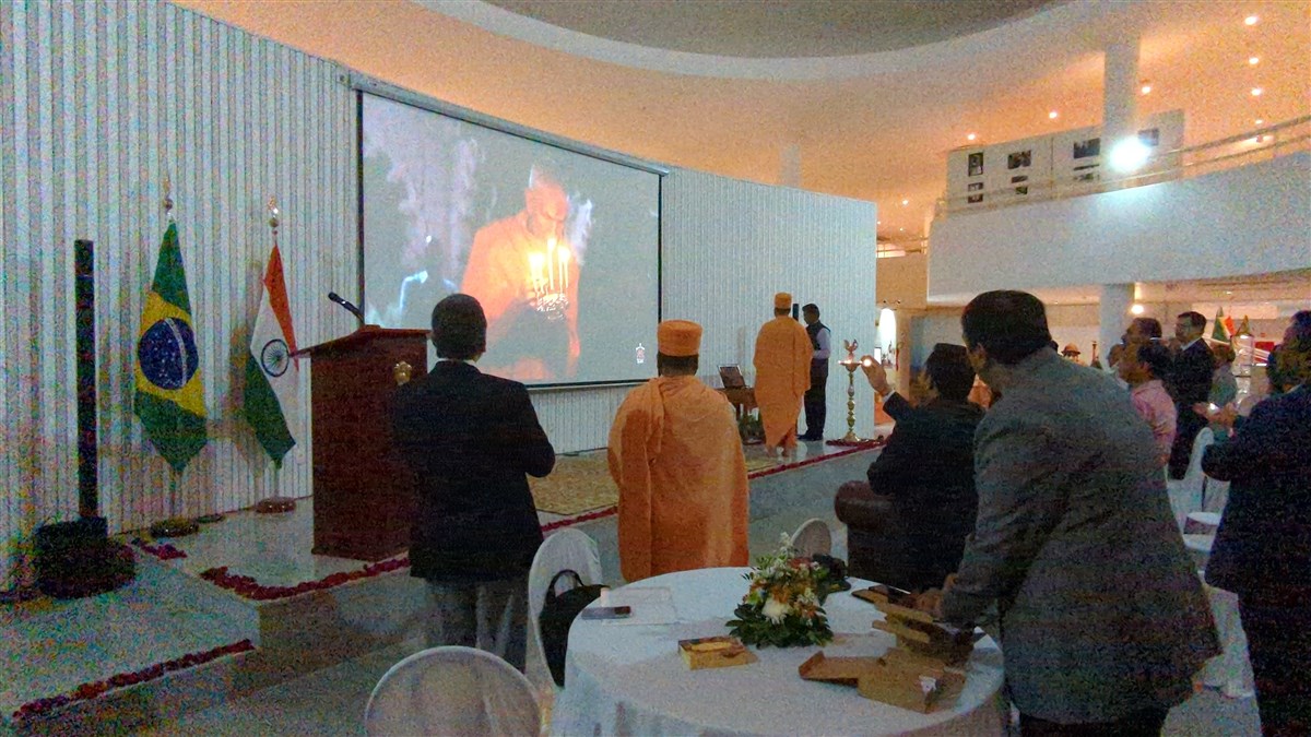 Devotees and well-wishers gathered at the Indian Embassy in Brasilia take part in the arti