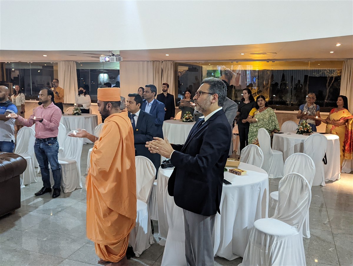 Devotees and well-wishers gathered at the Indian Embassy in Brasilia take part in the arti