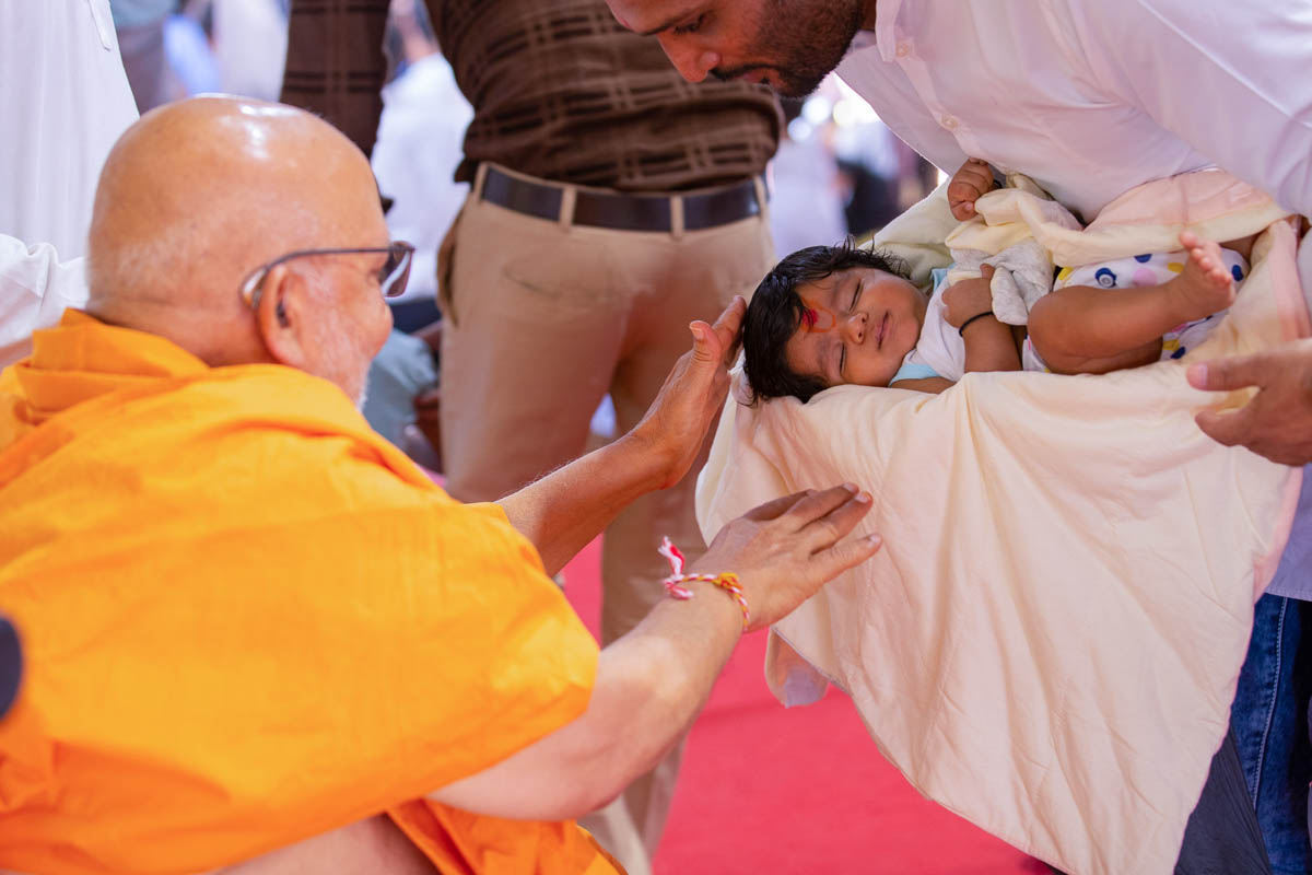 Pujya Ghanshyamcharan Swami blesses a child