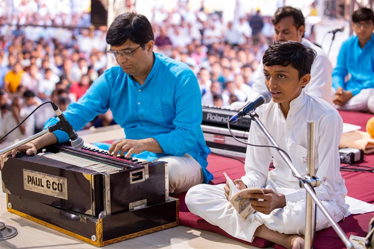 A balak sings a kirtan in Swamishri's morning puja