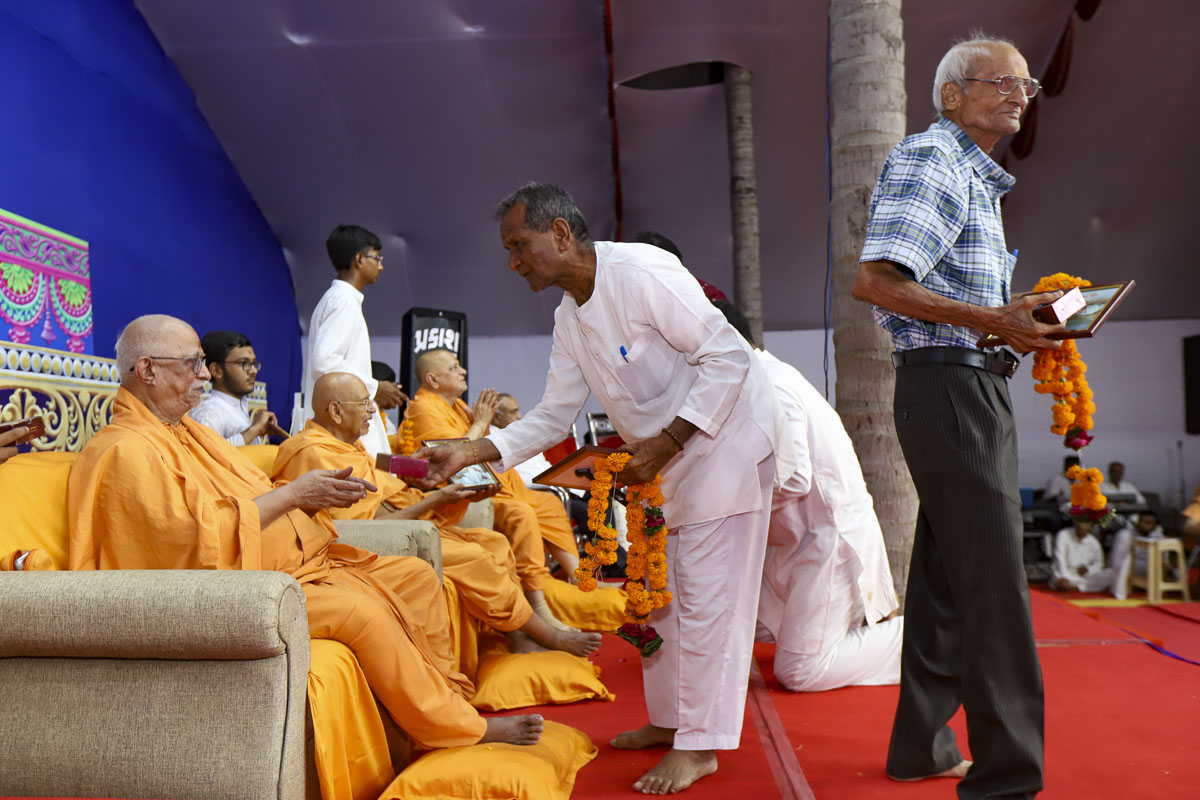 Senior sadhus present mementos to well-wishers and volunteers