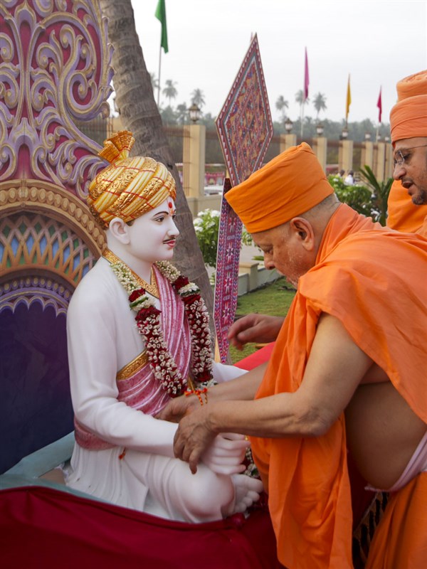 Pujya Ishwarcharan Swami ties a nadachhi to Brahmaswarup Bhagatji Maharaj