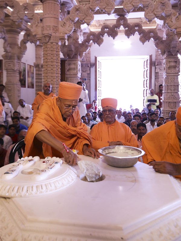 Pujya Doctor Swami pours cement in the pit