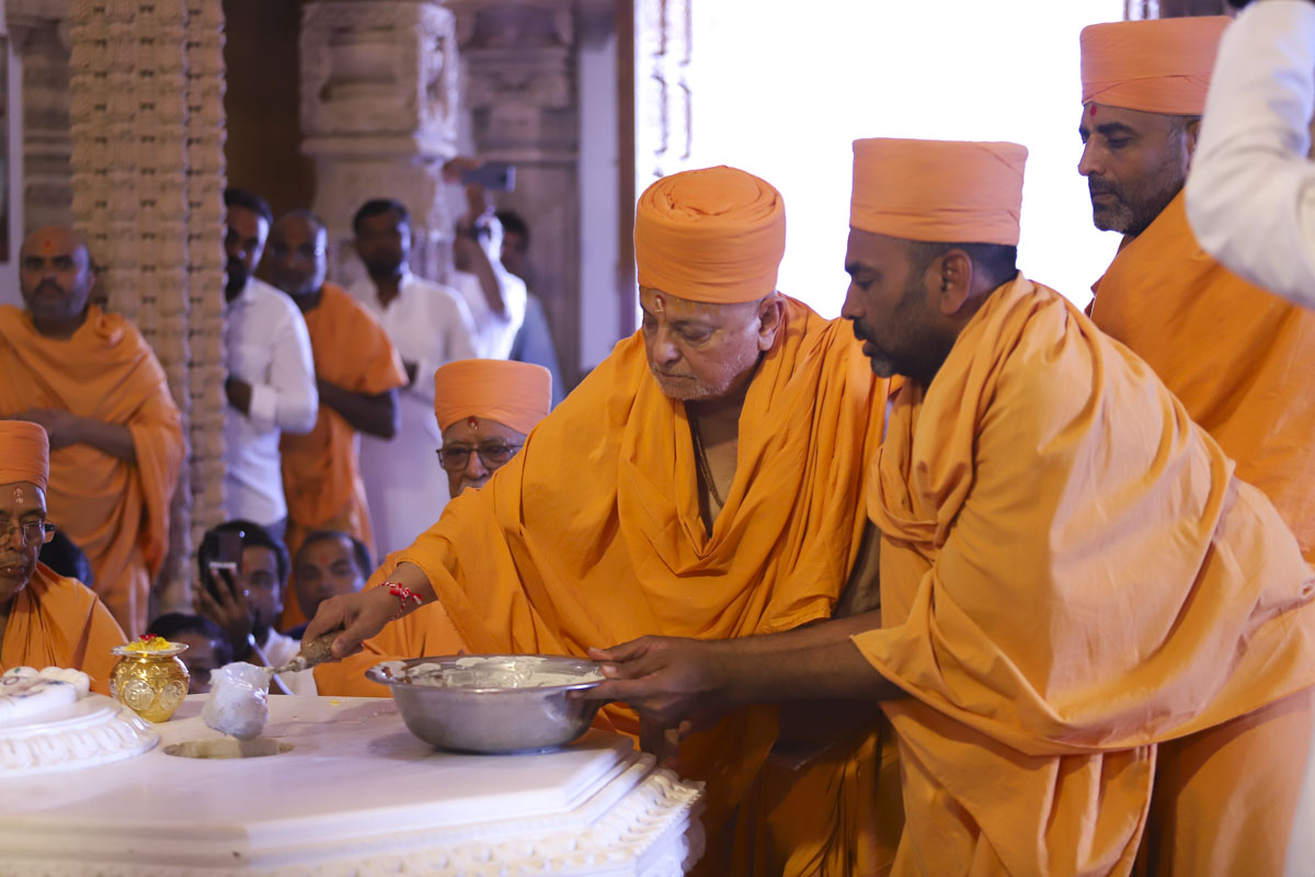 Pujya Ishwarcharan Swami pours cement in the pit