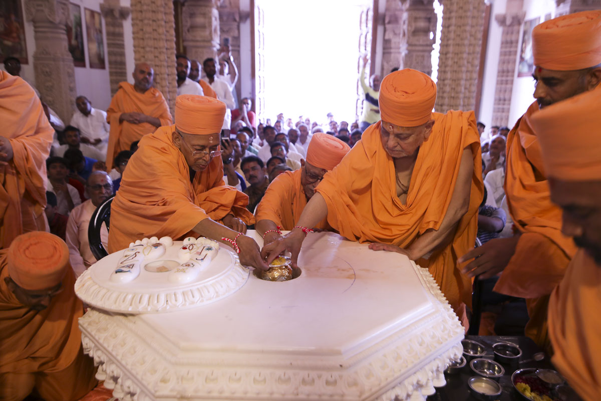 Pujya Ishwarcharan Swami and Pujya Tyagvallabh Swami place a kumbh in the charanarvind base