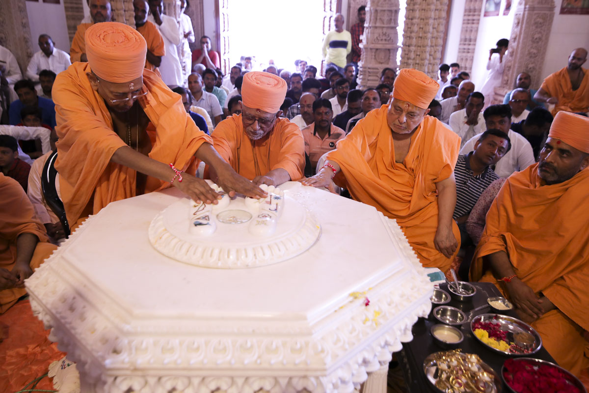 Pujya Doctor Swami, Pujya Ishwarcharan Swami and Pujya Tyagvallabh Swami place a kumbh in the charanarvind base