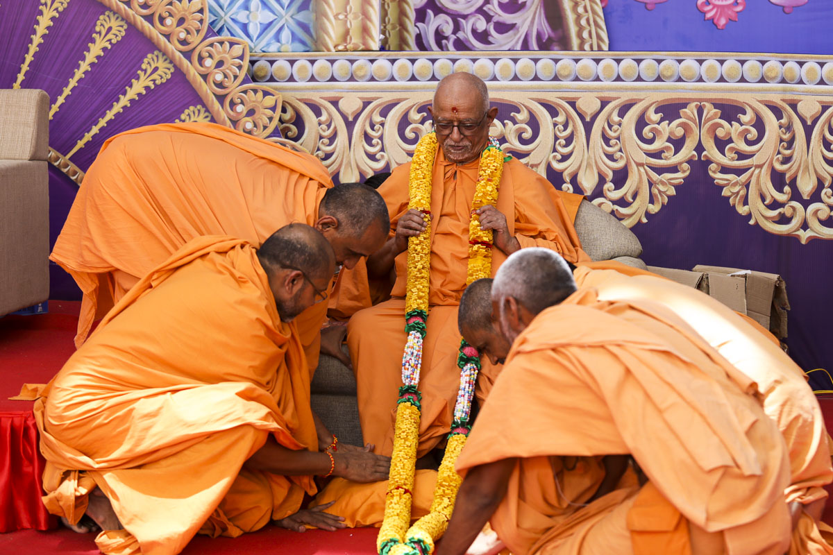 Sadhus honor Pujya Doctor Swami with a garland