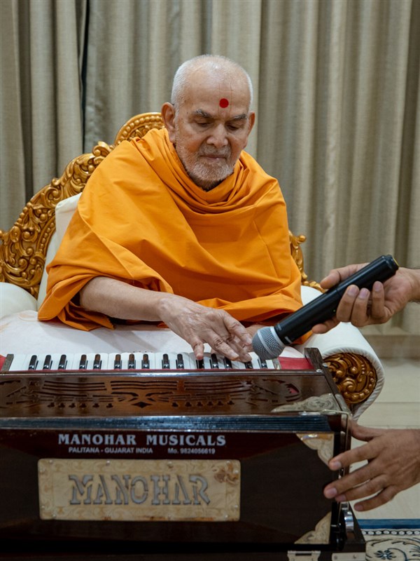 Swamishri plays the harmonium