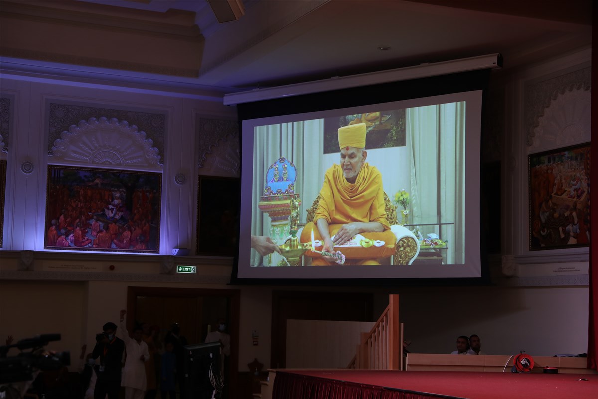 Thousands in the assembly in London and those joining online watched Mahant Swami Maharaj perform the deep pragatya