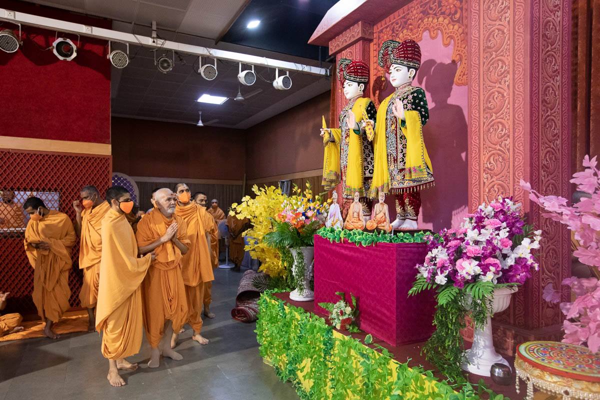 Swamishri engrossed in darshan of Bhagwan Swaminarayan, Aksharbrahma Gunatitanand Swami and Shri Guru Parampara