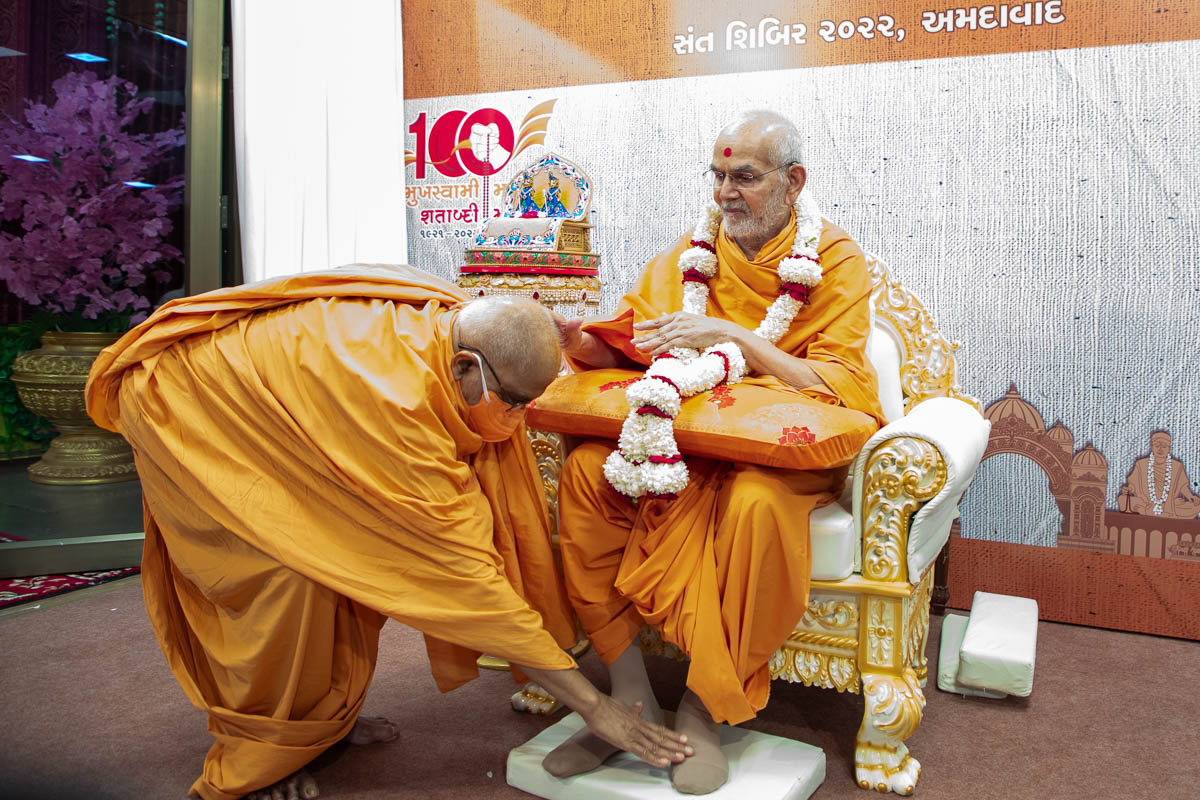Shrihari Swami honors Swamishri with a garland