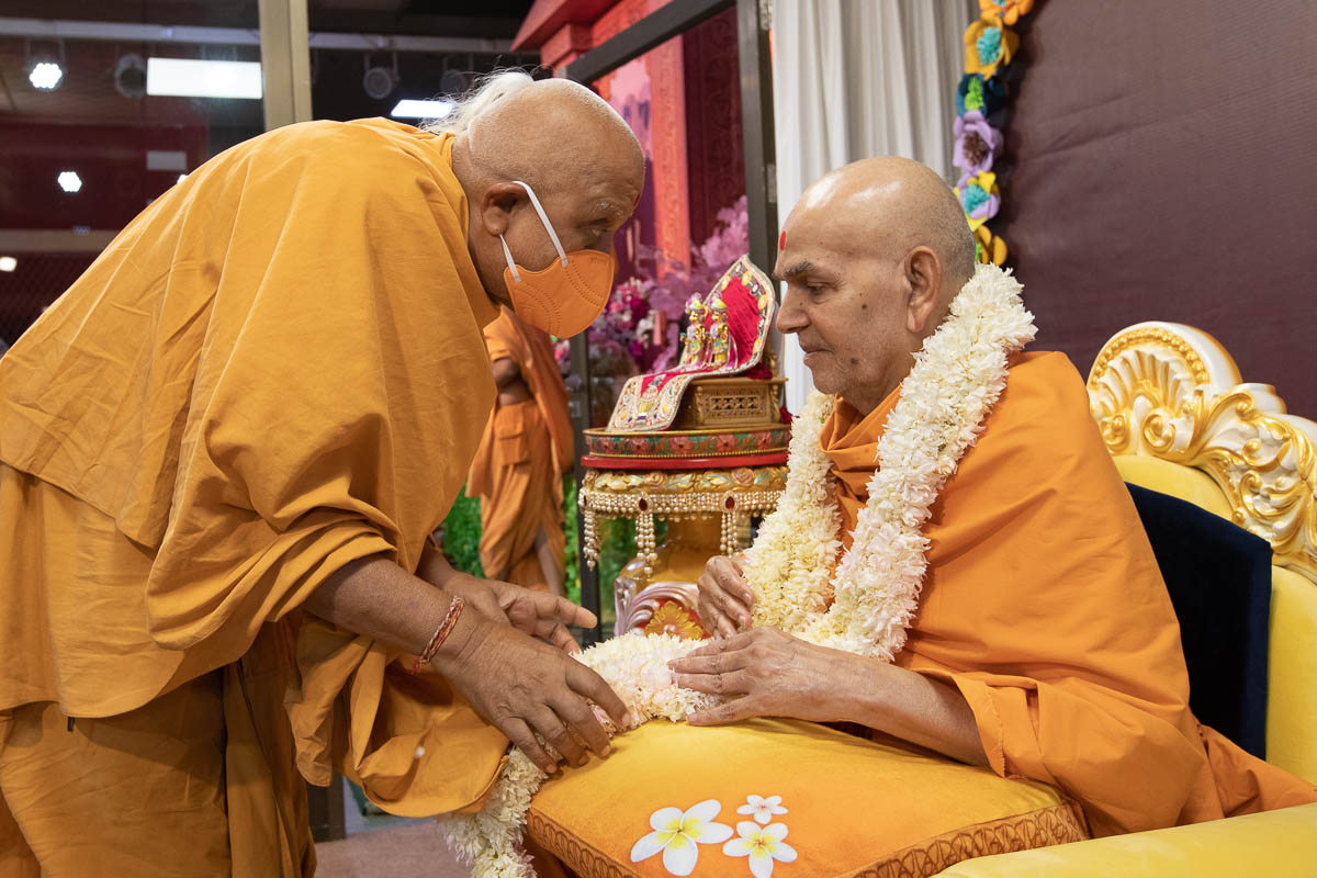 Bhaktavatsal Swami honors Swamishri with a garland