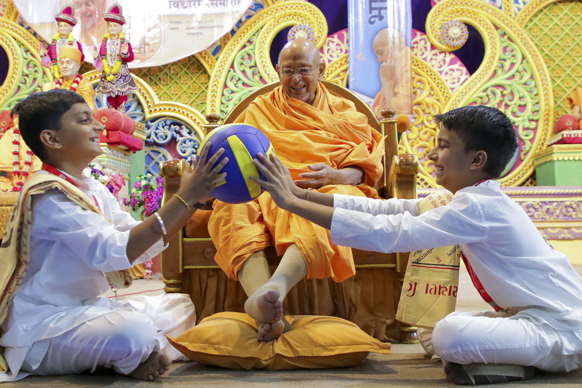 Pujya Tyagvallabh Swami and balaks participate in an activity
