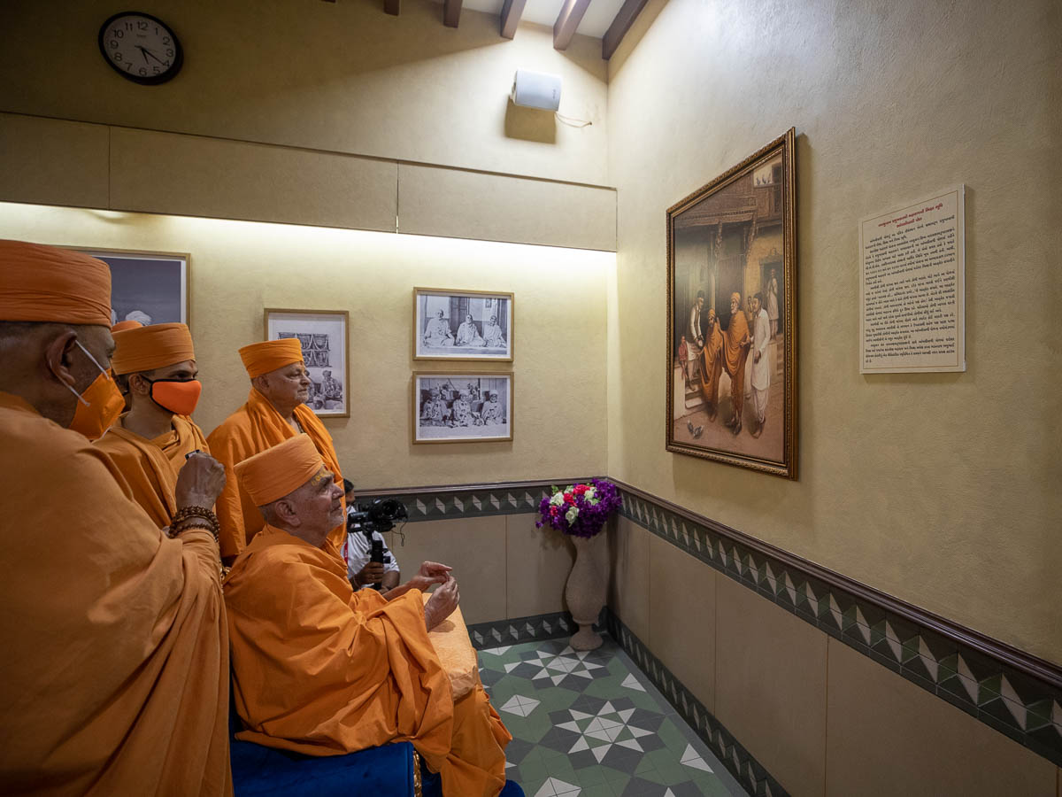 Swamishri observes a painting of Brahmaswarup Shastriji Maharaj collecting alms in Ambli Vali Pol