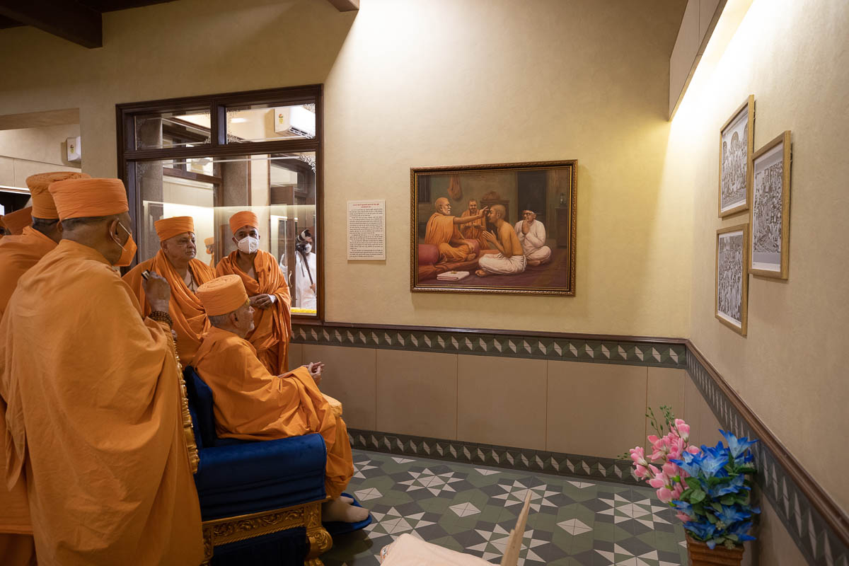 Swamishri observes a painting of Brahmaswarup Shastriji Maharaj gives parshad diksha to Shantilal