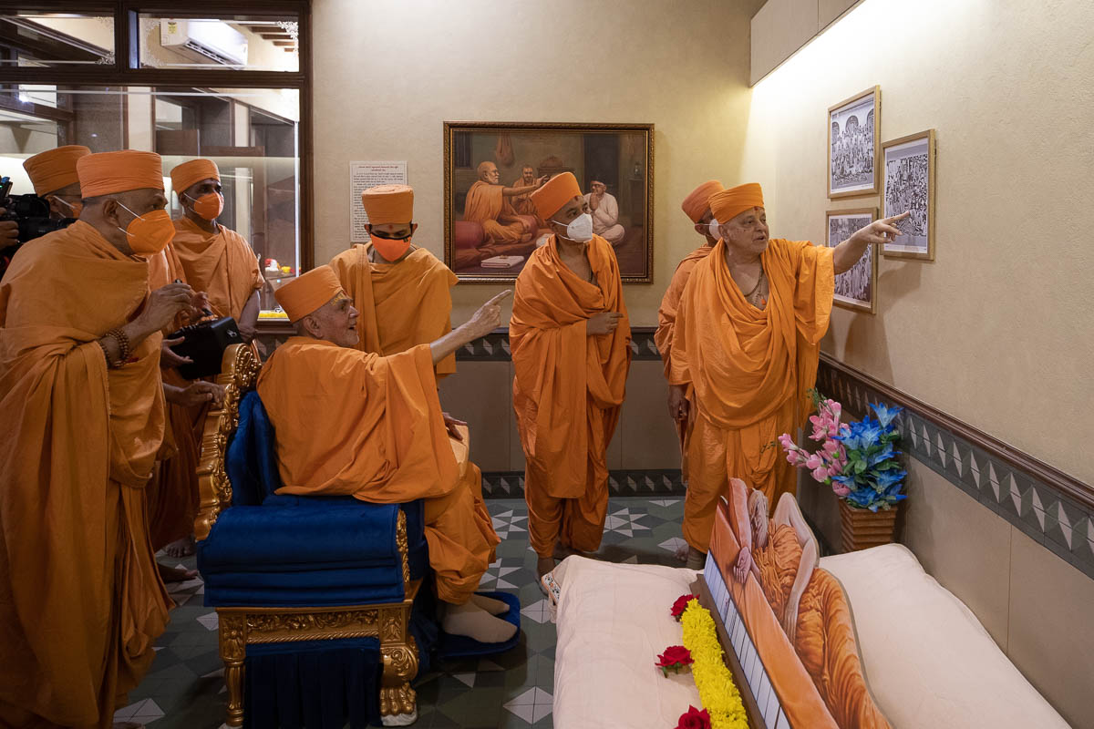 Swamishri observes photos of Brahmaswarup Shastriji Maharaj and devotees