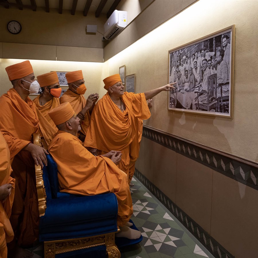 Swamishri observes photos of Brahmaswarup Shastriji Maharaj and devotees from Africa