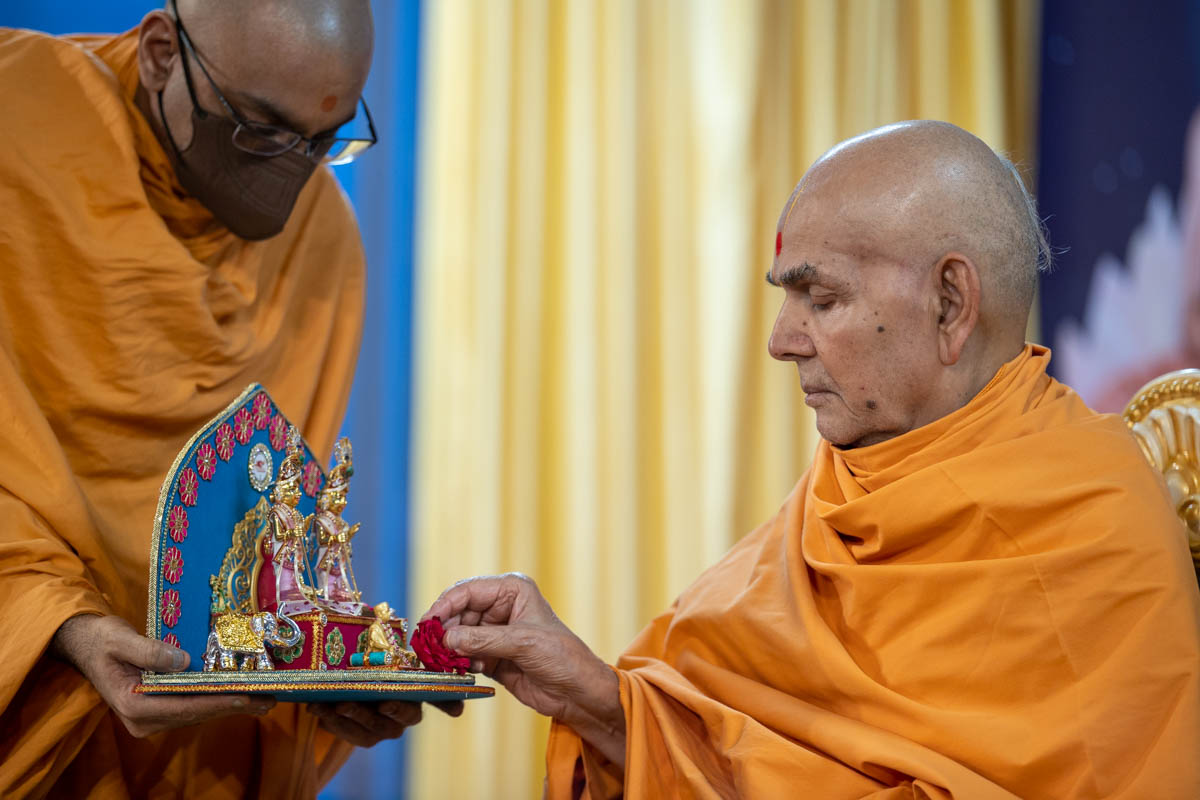 Swamishri offers a flower to Brahmaswarup Pramukh Swami Maharaj
