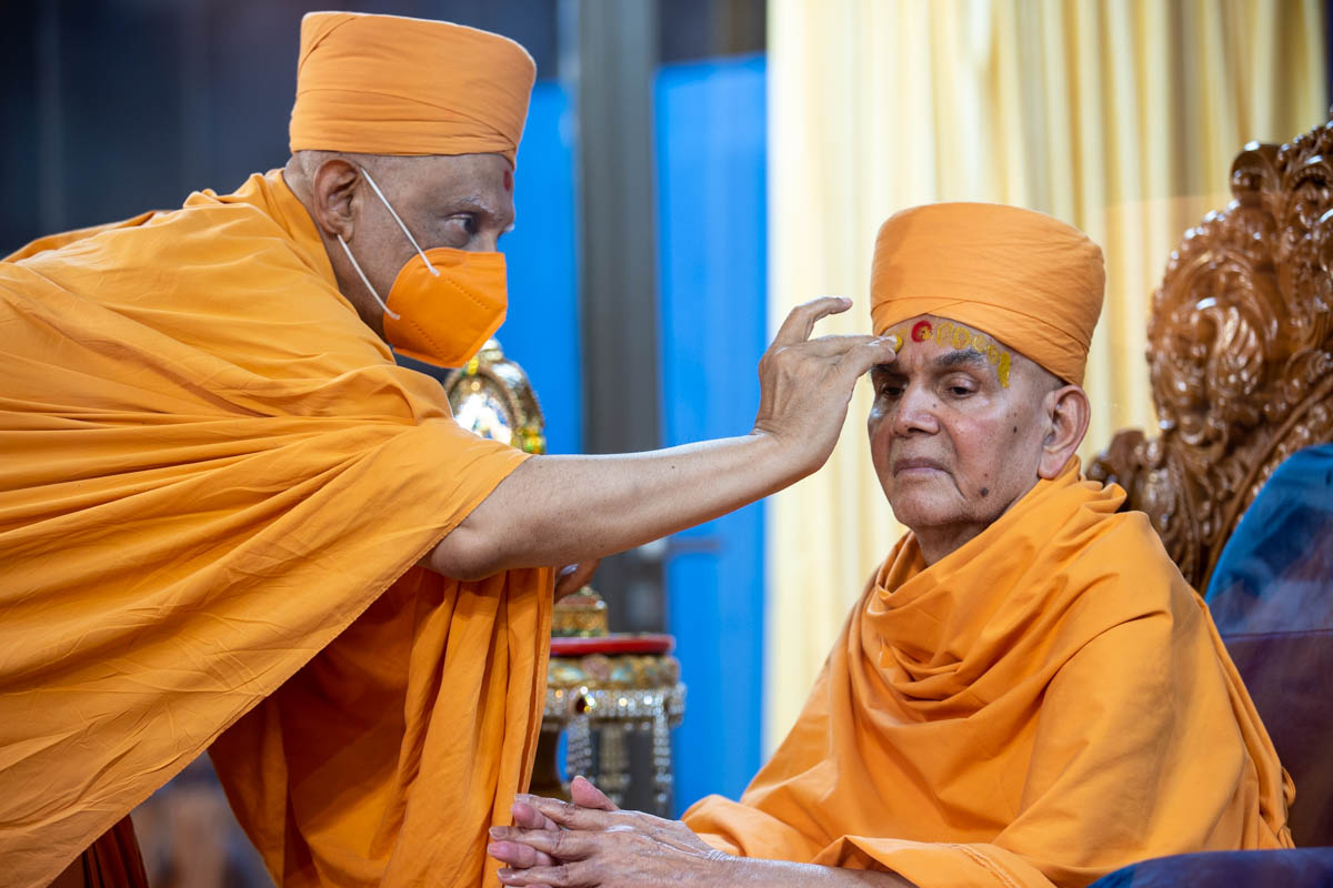 Atmaswarup Swami applies chandan archa to Swamishri