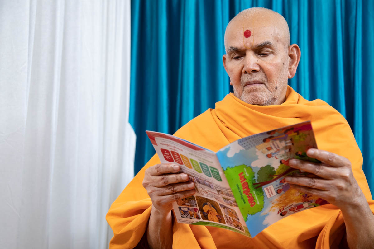 Swamishri reads the latest Gujarati issue of 'Swaminarayan Bal Prakash'