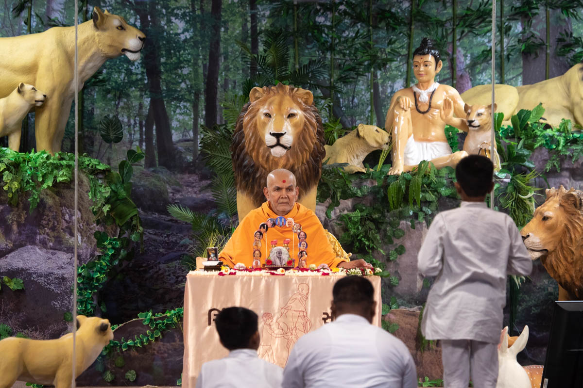 Swamishri listens to a balak presenting mukhpath