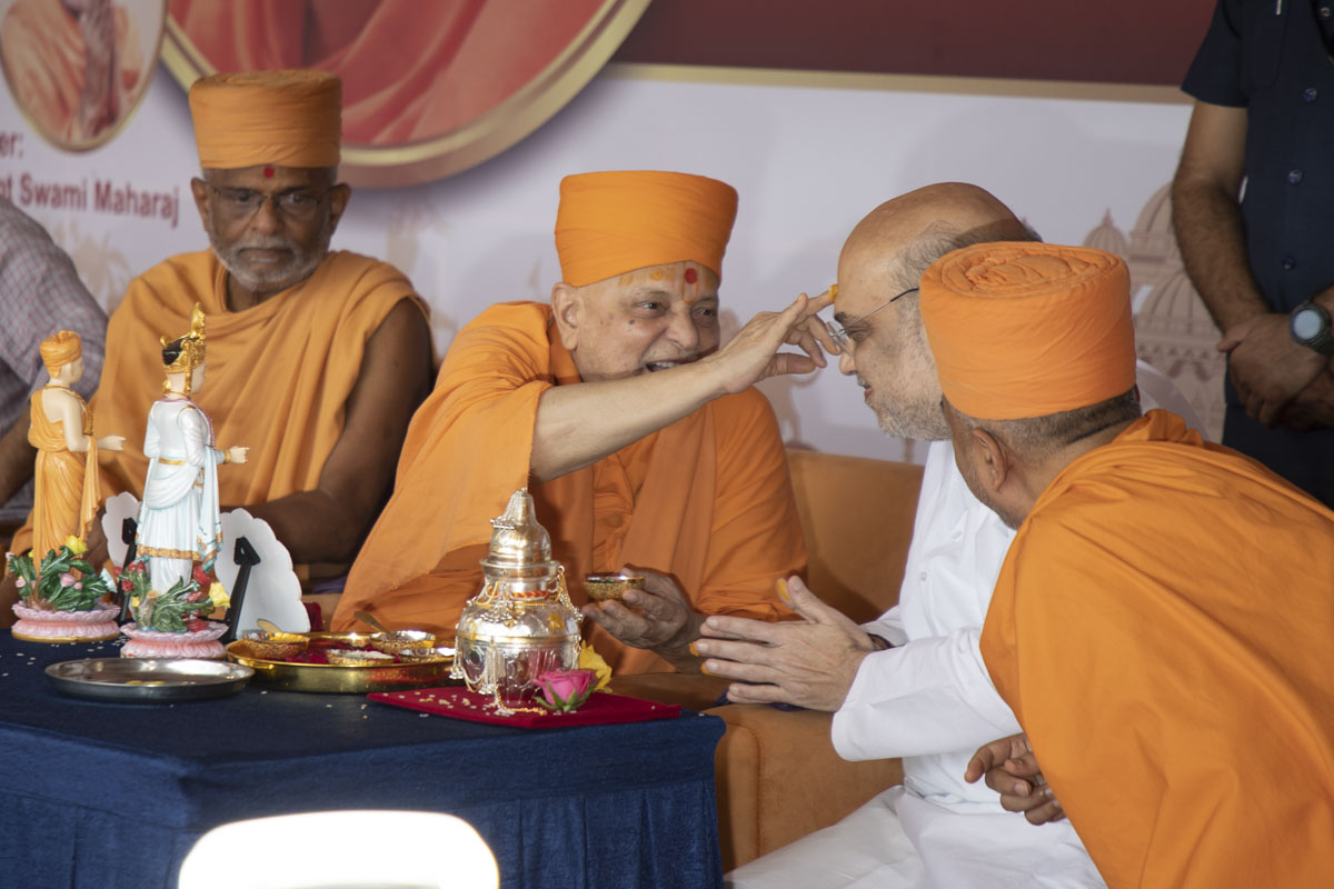 Pujya Ishwarcharan Swami applies a chandlo to Shri Amitbhai Shah