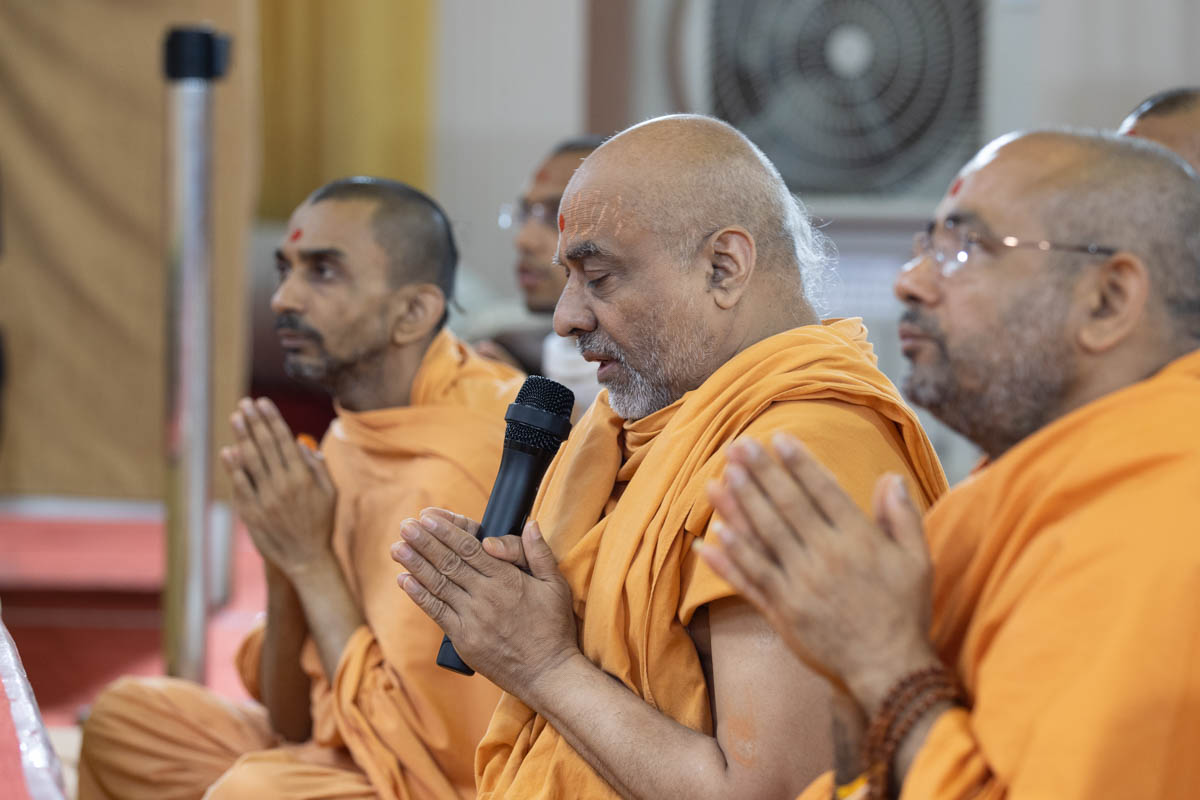 Aksharjivan Swami leads everyone in reciting the sadhana mantra and daily prayer in Swamishri's puja