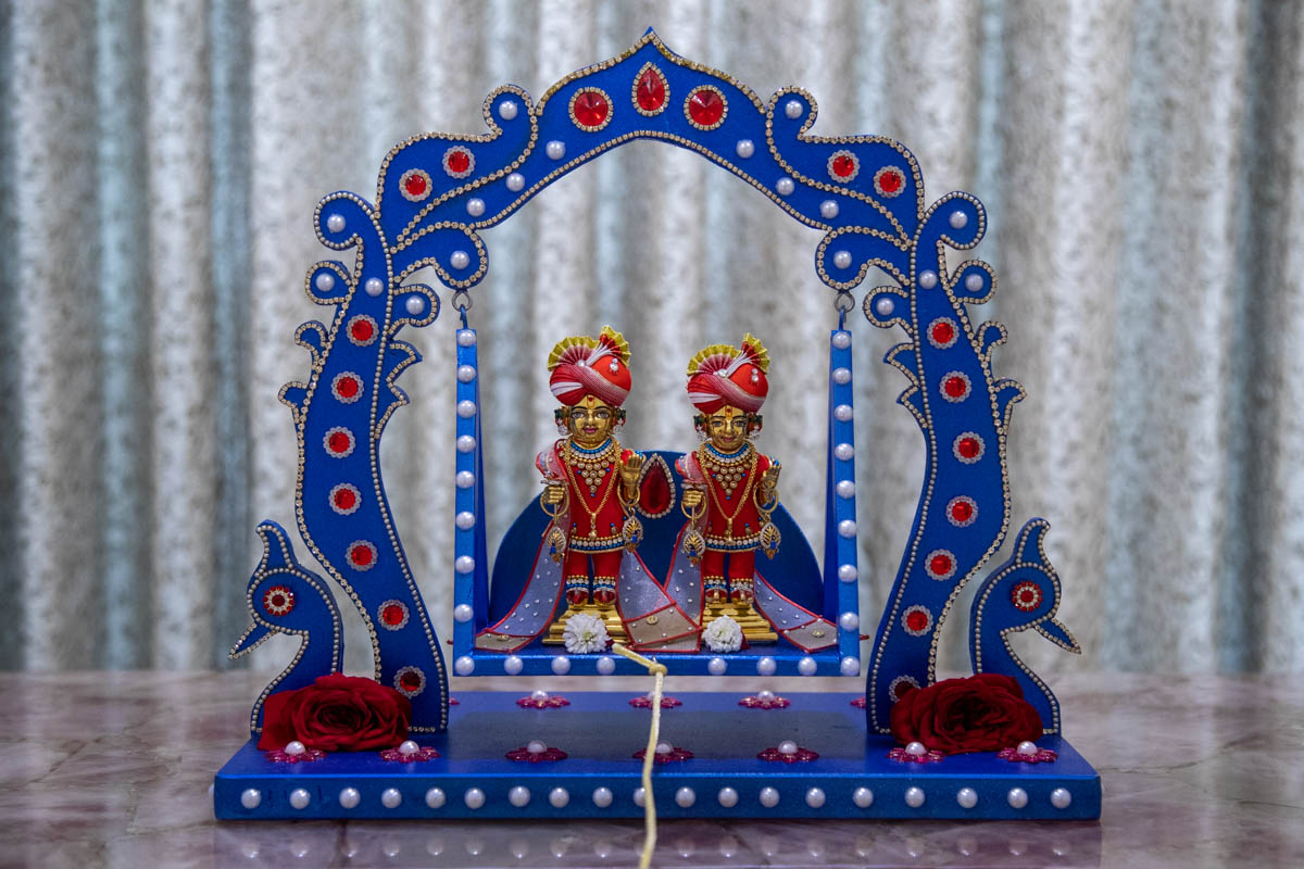 Shri Harikrishna Maharaj and Shri Gunatitanand Swami in a decorative hindolo