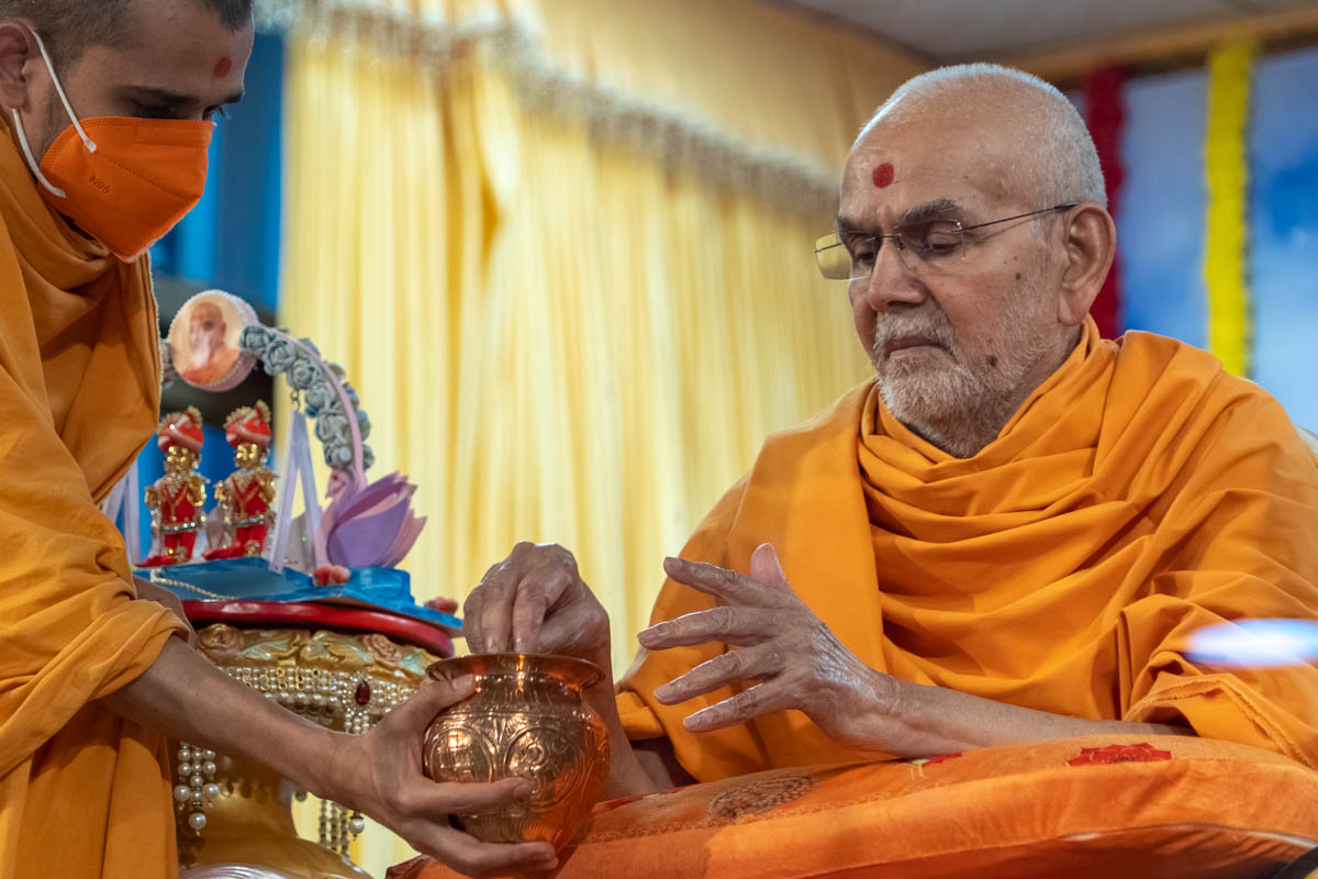 Swamishri sanctifies akshat (rice grains)