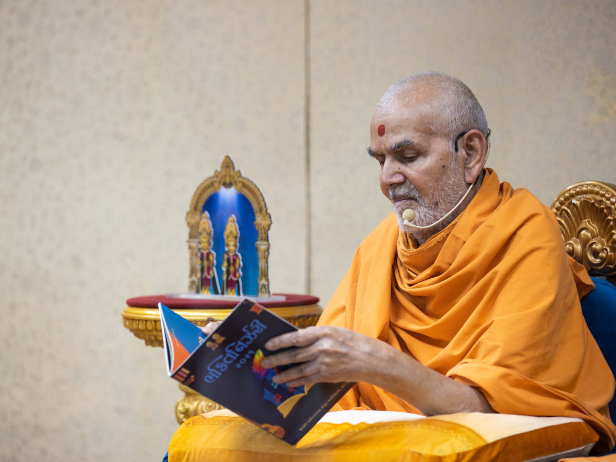 Swamishri observes a book 'Bhaktinirjhari'