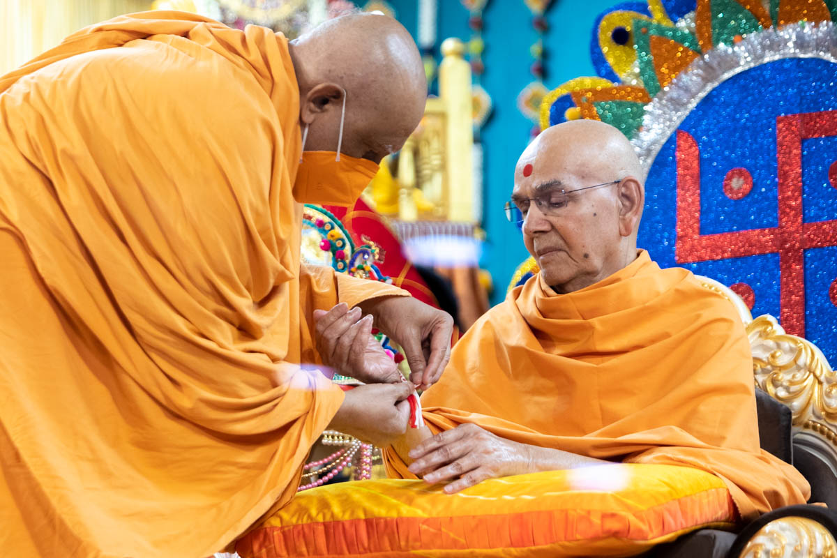 Atmaswarup Swami ties a rakhdi to Swamishri